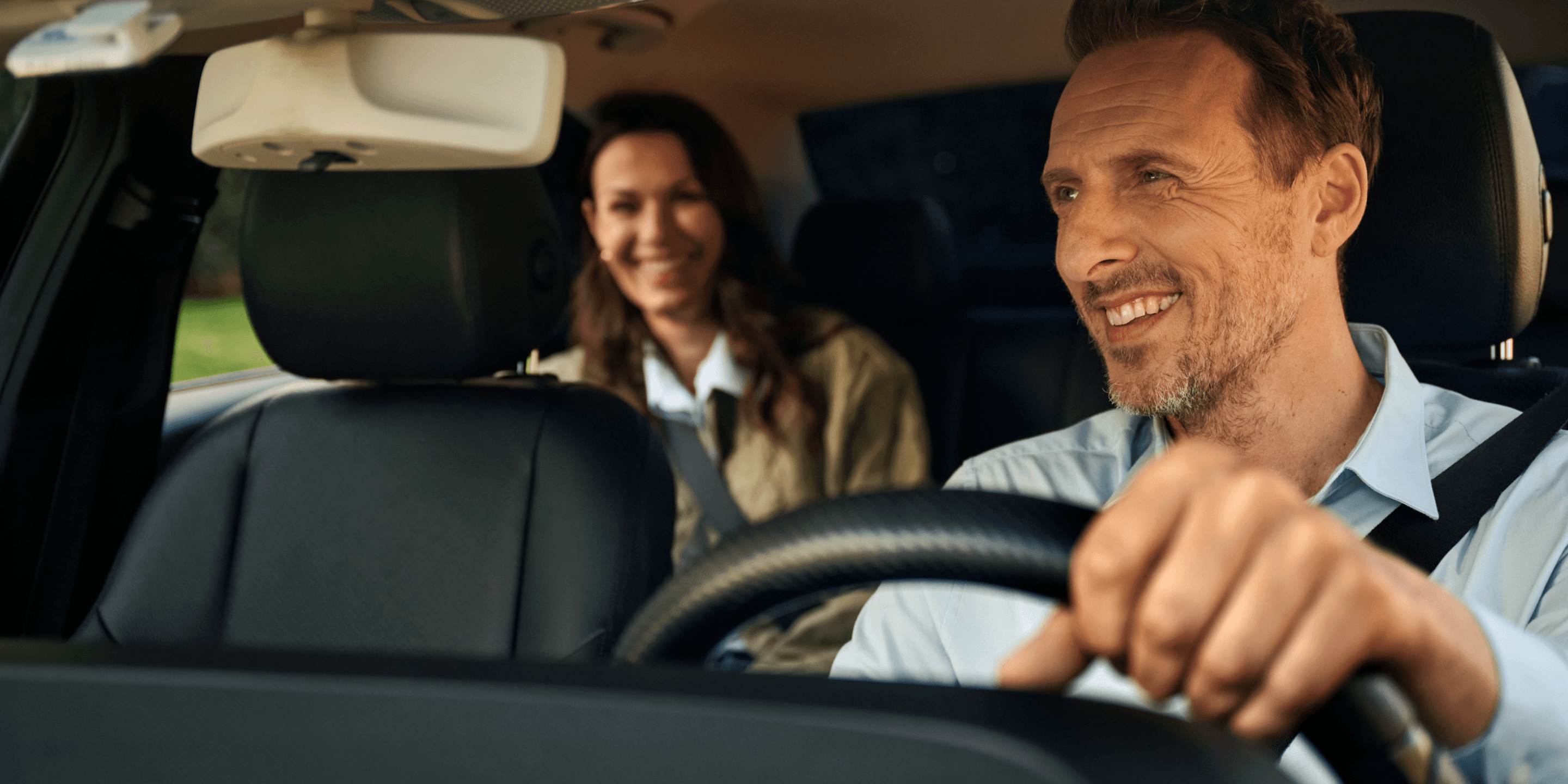 satisfied employee sitting in his car looking at his phone